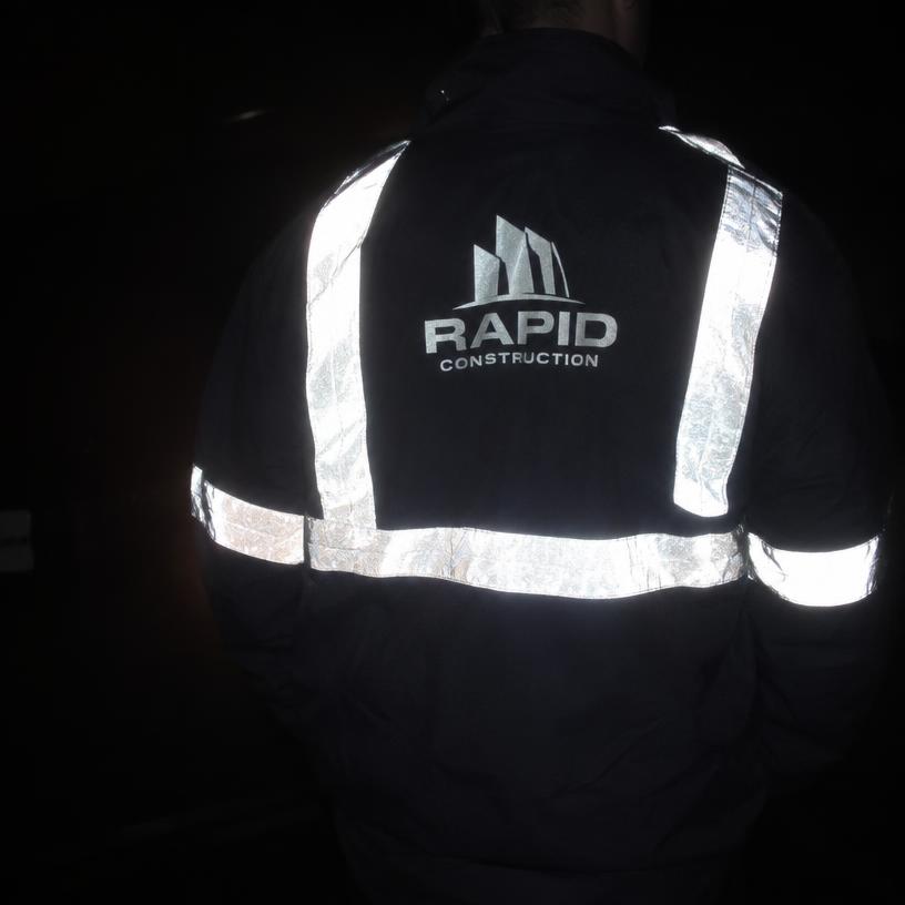 Reflecterende folie op een donkere werkjas licht op onder flitslicht